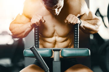 Bodybuilder strong man pumping up abs muscles