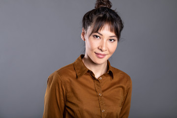 Attractive asian woman on gray background. Portrait of a female student.