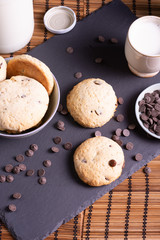 bol con galletas de chocolate pepitas leche en pizarra con vela leche tapón en esterilla en una botella