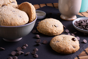 bol con galletas de chocolate pepitas leche en pizarra con vela leche tapón en esterilla en una botella