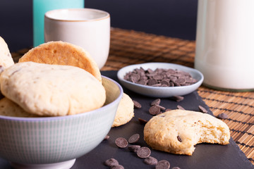 bol con galletas de chocolate pepitas leche en pizarra con vela leche tapón en esterilla en una...