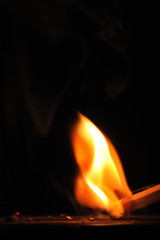 Matchstick ignites with the help of the matchbox with beautiful flames and smoke.