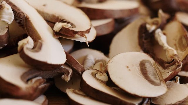 Pile Of Sliced Portabella Mushrooms. Handful Of Raw Fungus Drops Onto A Pile For Plant Based Meal Prep. Macro Shot Shows Healthy Vegan Lifestyles And Meat Protein Alternatives.