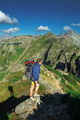 a man with backpack with mountains on background