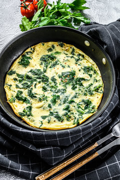 Spinach cheese frittata in a pan. Gray background. Top view