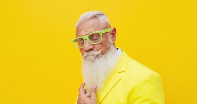 Senior man hipster with funny colored outfit on colored backgrounds