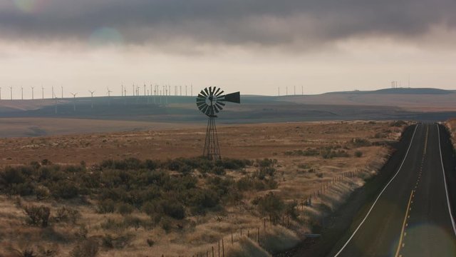 Tracking shot of windmill on side of road