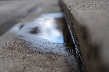 Reflektionen in einer Wasserlacke auf einer Stiege