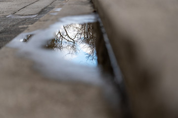 Reflektionen in einer Wasserlacke auf einer Stiege