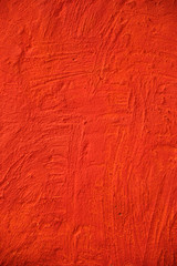 Textured stone wall painted with bright scarlet paint
