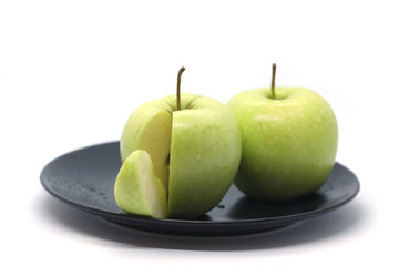Green apples on a plate isolated on a white background.