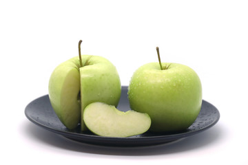 Green apples on a plate isolated on a white background.