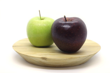 Green and red apple on a plate isolated on a white background.
