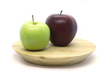 Green and red apple on a plate isolated on a white background.