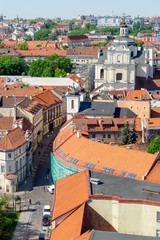 Fototapeta premium Panorama of Vilnius Old Town from the tower of St. John's Church on a sunny spring day. Dominican Street. Old and new dwellings, Sanctuary of the Divine Mercy, Dominican Church of the Holy Spirit