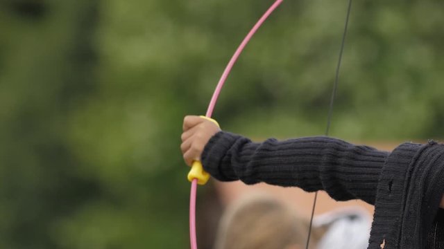 Young Black Girl aims with Arrow and Bow at Archery Camp then Shoots