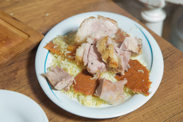 Lamb and beef on a wooden table in a white plate . The cooked and chopped mutton is inside the plate.