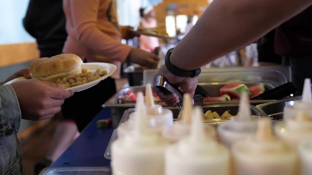 Hungry Campers Fill Up plates from food at table with camp food