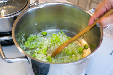 Chef hand roasting onions and peppers for dinner. Food preparation and cooking concept.
