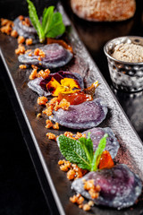 Ukrainian cuisine in the European style. Sweet dumplings with cherries, candied orange and edible flowers. Beautiful serving in the restaurant. background image, copy space text