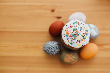 Homemade easter cake with colorful sprinkles and stylish easter eggs natural dyed on rustic wooden table,flat lay. Happy Easter. Traditional Easter bread. Copy space