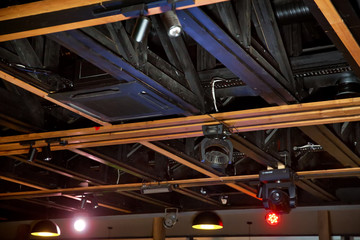 Obraz premium LED down light isolated on black background. Lights and ventilation system in long line on ceiling of the dark office industrial building, Restaurant Hall Ceiling construction .