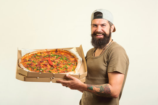 Smiling young delivery man holding pizza box.