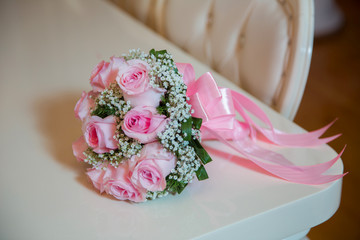 pink engagement flowers on white table . Pink engagement bouquet . pink ribbon .