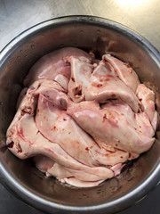 Raw cod fish liver with blood in stainless steel bowl plate