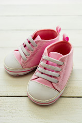 Fototapeta na wymiar Pink baby girl shoes, on gray background. Newborn, motherhood, pregnancy concept with copy space.
