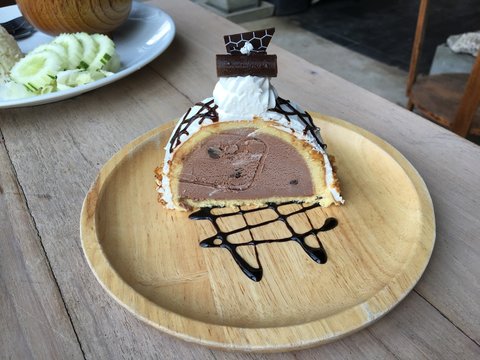 Chocolate ice cream cake placed on a wooden plate