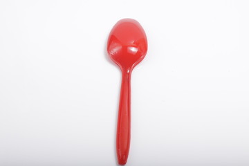 Red plastic cutlery on an isolated white background