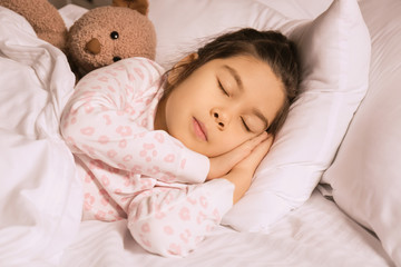 Obraz na płótnie Canvas Cute little Asian girl sleeping in bed at night