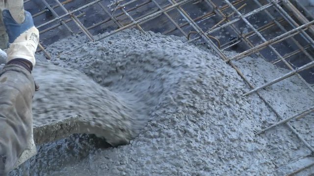Builders at the construction site pour the surface with a mixture of cement and small gravel to concrete the construction site of a residential building