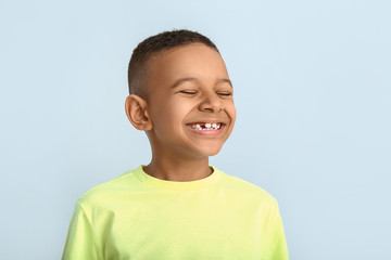 Happy smiling African-American boy on color background