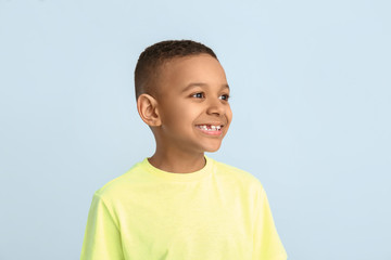 Happy smiling African-American boy on color background © Pixel-Shot