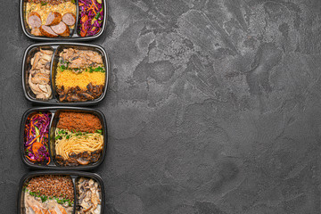 Containers with healthy food on dark background