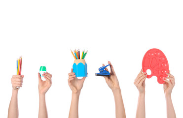 Many hands with school supplies on white background