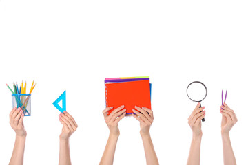 Many hands with school supplies on white background