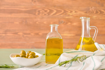 Bottles of tasty olive oil on wooden table