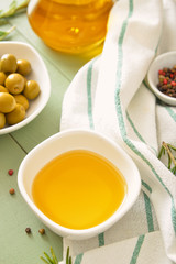 Bowl of tasty olive oil on wooden table