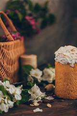 Traditional Russian Orthodox Easter bread kulich with apple blossom and colored eggs in rustic style background with a basket
