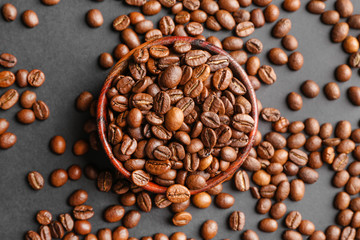 Bowl with coffee beans on dark background