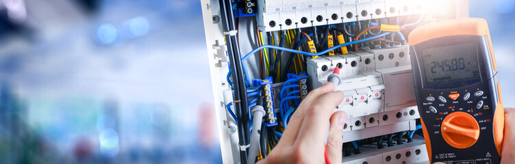 Electrician engineer installing and test electric connection wires of fuse switch box.