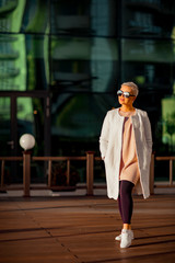 Young woman, blonde, walks in sunglasses