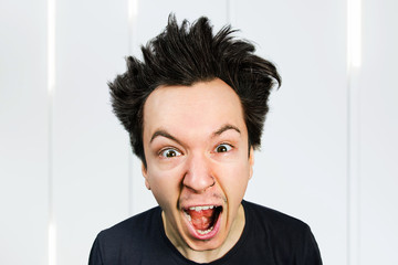 Sad anger young guy look in camera and cry with open mouth and scream, on white background.