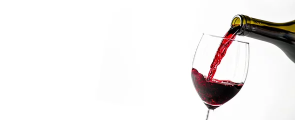  Pouring glass of red wine from a bottle in wide banner shape or copy space for text.. White background or isolated. © Milan