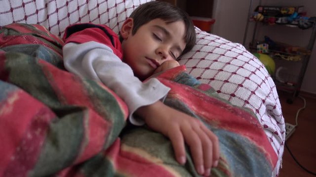 4K Sick rattling child sleeping under blanket on sofa