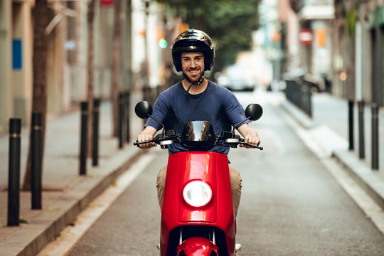 Close up bearded guy smiling with motorcycle in Barcelona