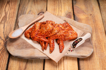 Raw pickled chicken wings on a blue plate on a wooden background. Chicken marinated meat.